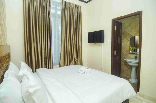 a bedroom with a white bed and a sink at GILI VIEW By Maza in Teluk Nara