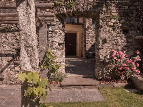 an entrance to a stone building with a door and flowers at B&B CCAA Ascona in Ascona