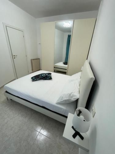a bedroom with a white bed and a mirror at Alcione113 Apartment in Francavilla al Mare