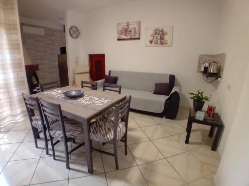 a living room with a table and chairs and a couch at Da zia Barbara in Sìnnai