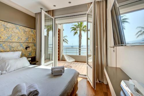 a bedroom with a bed and a view of the ocean at Hôtel Bor in Hyères
