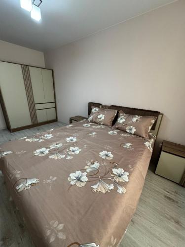 una camera da letto con un grande letto decorato con fiori di Candy Apartment a Chişinău