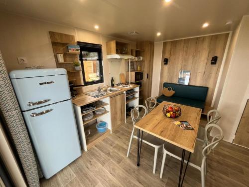 una piccola cucina con frigorifero e tavolo di Camping Ostréa **** a Dolus-d'Oléron