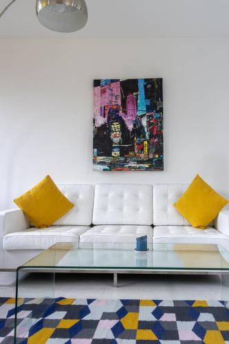 a living room with a white couch with yellow pillows at GuestReady - Luxurious Ballsbridge house in Dublin