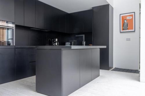 a kitchen with black cabinets and a counter top at GuestReady - Luxurious Ballsbridge house in Dublin