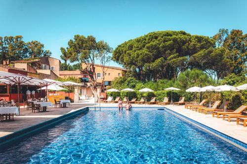 - une piscine avec des chaises et des parasols dans un complexe dans l'établissement Hôtel La Mandarine, à Saint-Tropez