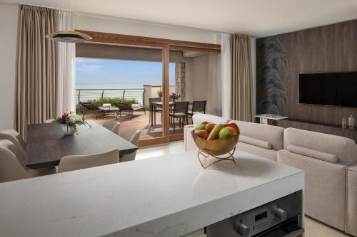 a living room with a table with a bowl of fruit on it at Tivoli Portopiccolo Sistiana Apartments in Sistiana