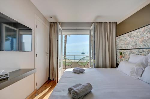 1 dormitorio con 1 cama grande y vistas al océano en Le Bor en Hyères