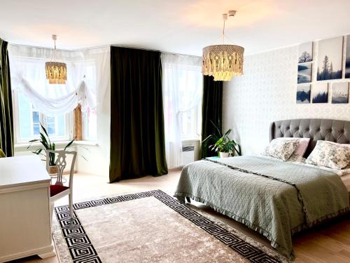 a bedroom with a bed and a chandelier at Rüütli 24-2 in Pärnu