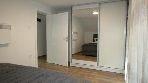 a bedroom with a sliding glass door leading to a bed at Kuća za odmor GAVRIĆ in Mrkonjić Grad