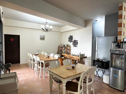 a dining room with tables and chairs and a refrigerator at Chuxu Homestay in Fanlu