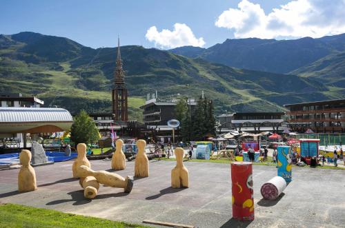 un groupe de statues en bois de personnes jouant à un jeu dans l'établissement Belambra Clubs Résidence Les Menuires - Le Hameau Des Airelles, aux Menuires