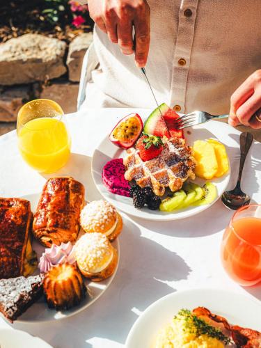 a person eating food on a table with plates of food at Hôtel La Mandarine in Saint-Tropez