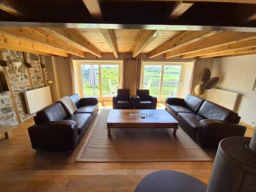 a living room with leather couches and a coffee table at La Grange - Gite Mur de Barrez in Mur-de-Barrez