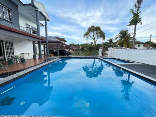 a large blue swimming pool in front of a house at MY VILLA PD in Port Dickson