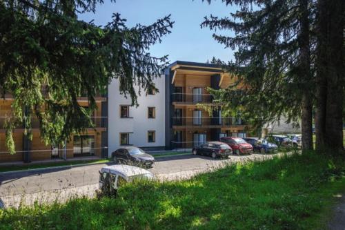 budynek z samochodami zaparkowanymi na parkingu w obiekcie Belambra Clubs Les Saisies - Les Embrunes - Ski pass included w mieście Villard-sur-Doron
