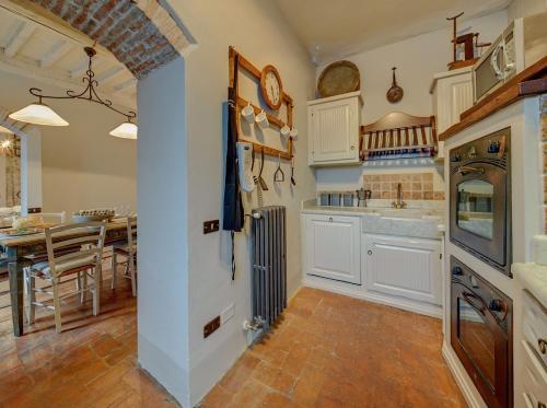 une cuisine avec des placards blancs et une salle à manger dans l'établissement Wonderful Serena, à Coreglia Antelminelli
