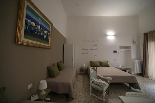 a bedroom with two beds and a couch and a painting at "Le Dimore degli Artisti" RIPACANDIDA in Ripacandida
