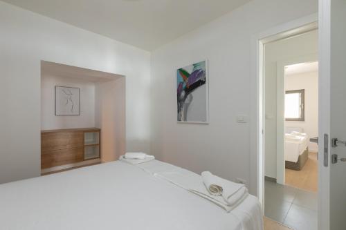 ein weißes Schlafzimmer mit einem Bett und einem Badezimmer in der Unterkunft Villa Brela apartments in Brela