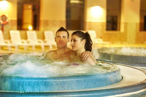 a man and a woman sitting in a hot tub at Camping Adria Ankaran - Pitches in Ankaran