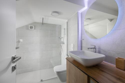 ein Badezimmer mit Waschbecken, Toilette und Spiegel in der Unterkunft Villa Brela apartments in Brela
