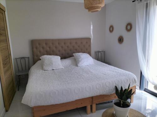 un lit avec des draps blancs et des oreillers dans une chambre dans l'établissement Villa Sofia, à Malemort-du-Comtat