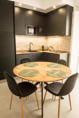 a kitchen with a wooden table and chairs at Torre Solana 41 in Cádiz