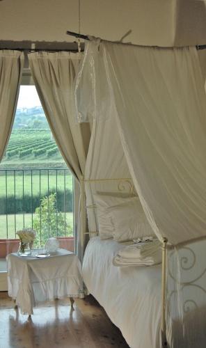 a bedroom with a canopy bed and a window at B&B Il Posto delle Rose in Almenno San Salvatore
