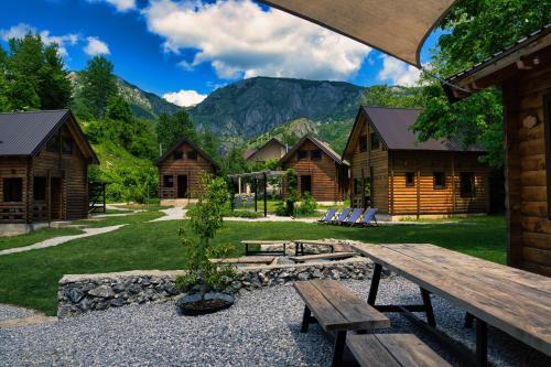a picnic table in the middle of a yard with houses at Camp Lipovo in Kolašin