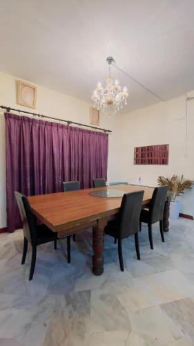 a dining room with a wooden table and chairs at MY VILLA PD in Port Dickson
