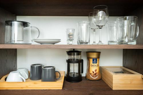 a wooden shelf with various glass items on it at Relaxační domek "Na kraji Brd" in Hŭrky