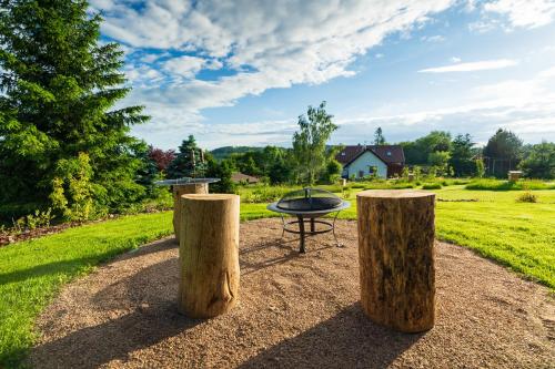 a barbecue grill in a park with trees and grass at Relaxační domek "Na kraji Brd" in Hŭrky