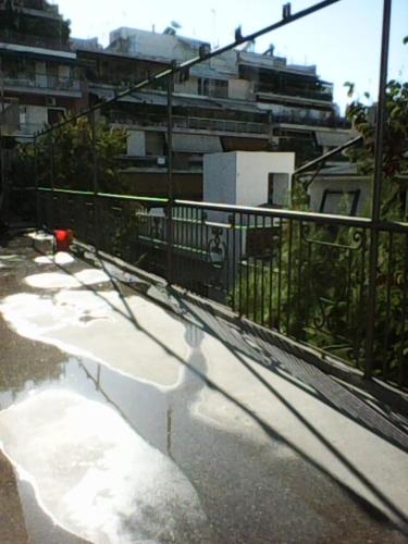 Ein Schatten eines Zauns auf einer Straße mit Gebäuden in der Unterkunft Frank Sinatra Apartment in Athen