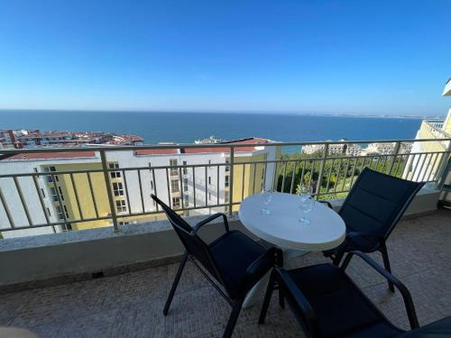 una mesa y sillas en un balcón con vistas al océano en Crown Imperial Fort Grand Resort en Elenite