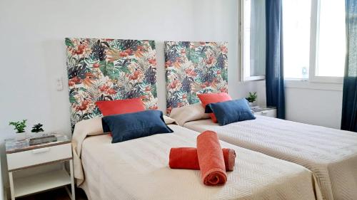 two beds with towels on them in a bedroom at Casa mirando al mar, hermosas vistas. in Chipiona