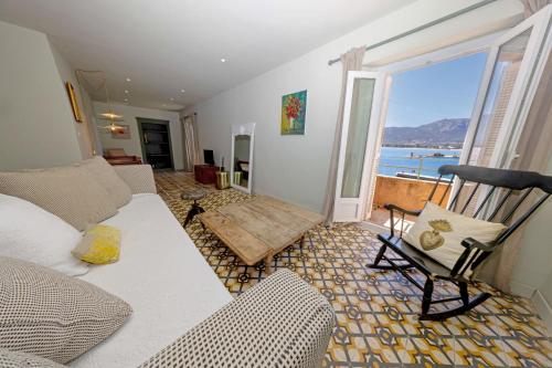 un salon avec un canapé et une vue sur l'océan dans l'établissement L'appartement Macci, au coeur du port avec vue spectaculaire, à Calvi