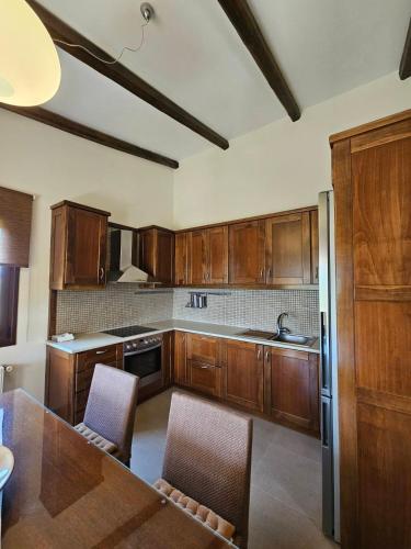a kitchen with wooden cabinets and a table with chairs at Orestis' Family House in Ermioni