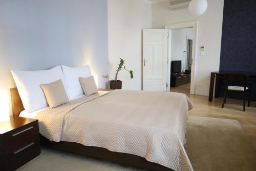 una camera da letto con un grande letto con lenzuola e cuscini bianchi di Rezidence Ostrovní a Praga