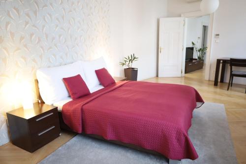 a bedroom with a large bed with a red blanket at Rezidence Ostrovní in Prague