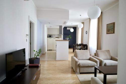 a living room with two chairs and a kitchen at Rezidence Ostrovní in Prague