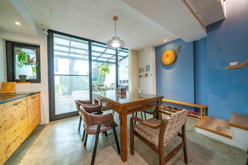 a dining room with a wooden table and chairs at Tree House in Tainan
