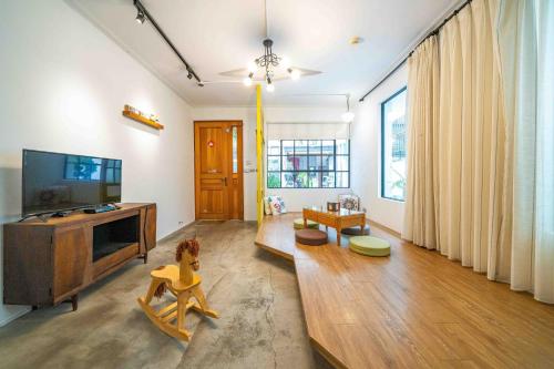 a living room with a flat screen tv and a couch at Tree House in Tainan
