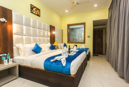 a bedroom with a large bed with blue and white pillows at Hotel Grand Nest in Dharamshala