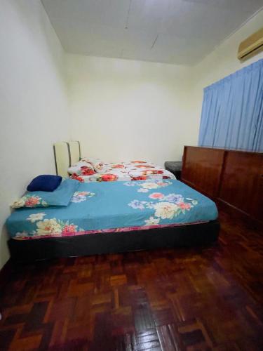 a bedroom with a bed with a blue comforter at MY VILLA PD in Port Dickson