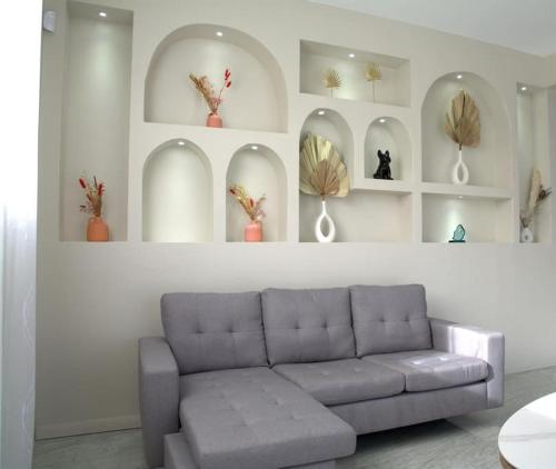 a living room with a couch and shelves with vases at Casa Blue Print Mahebourg in Mahébourg