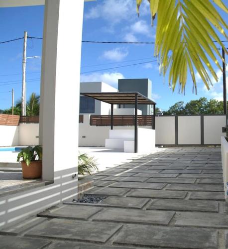 a porch of a house with a bench and a fence at Casa Blue Print Mahebourg in Mahébourg