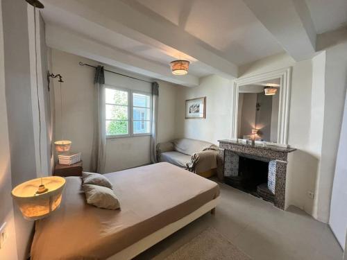 - un salon avec un lit et une cheminée dans l'établissement La Petite Épicerie, à Uzès