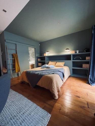 une chambre avec un lit et un mur bleu dans l'établissement Chambre dans maison de ville avec piscine et garage en centre ville, à Montpellier