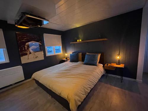 a bedroom with a large bed and two lamps at Poellodge XL, houseboat met whirlpool en sauna in Aalsmeer