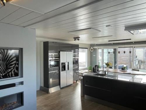 a kitchen with stainless steel appliances and a counter top at Poellodge XL, houseboat met whirlpool en sauna in Aalsmeer